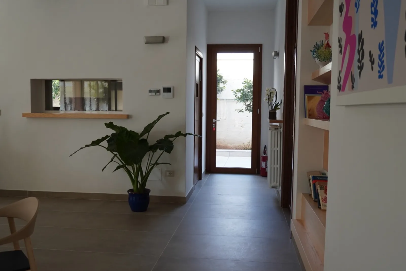Spazio comune di Lares con piante, libri e opere d'arte