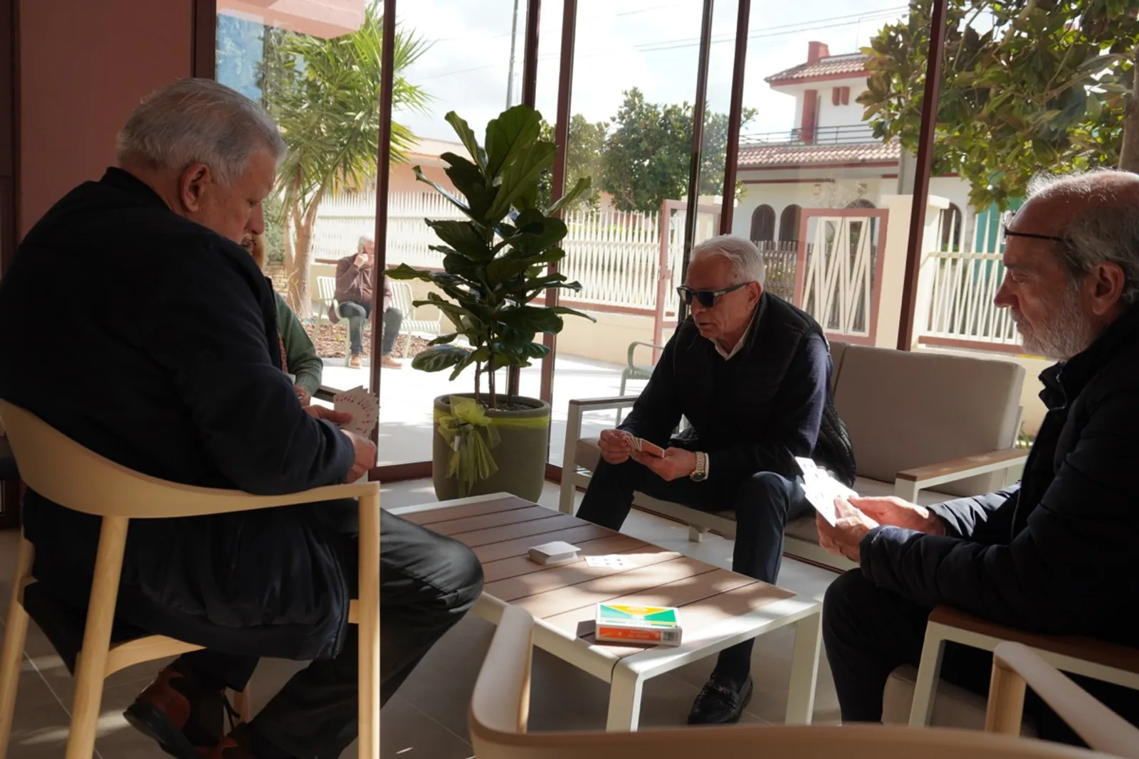 Residenti giocano a carte insieme nell'area comune di Lares Cohousing
