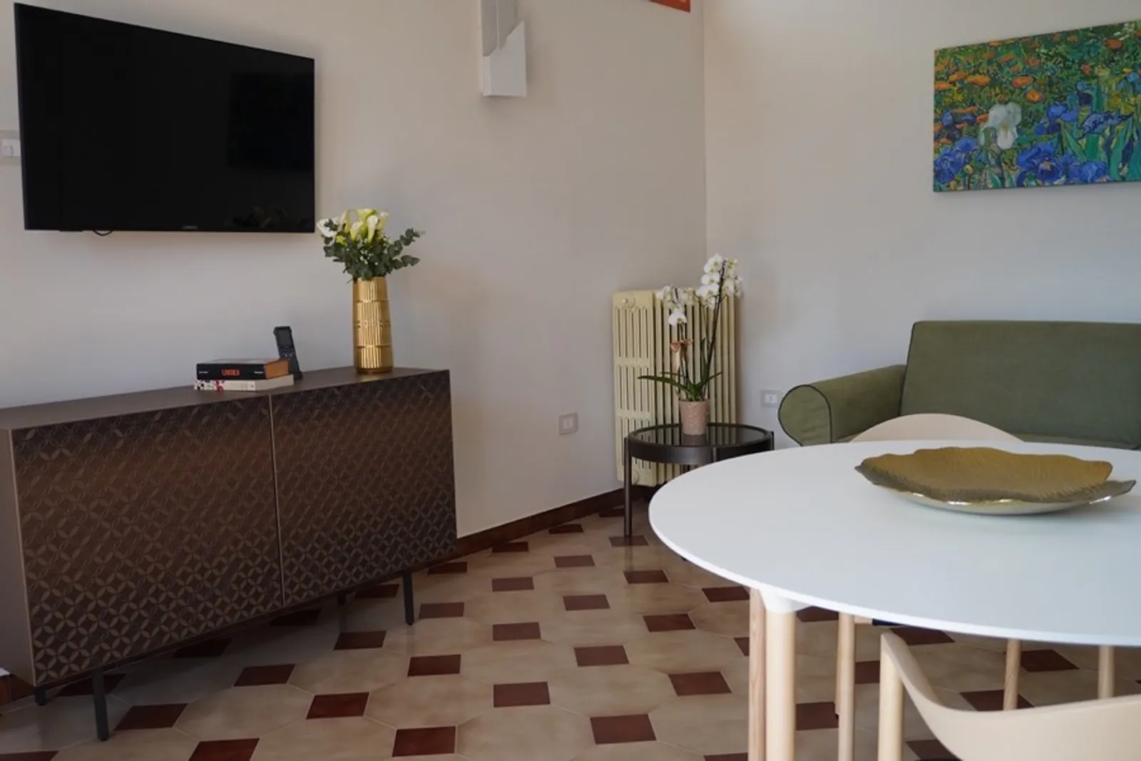 Soggiorno luminoso con divano e zona pranzo in appartamento Lares Cohousing